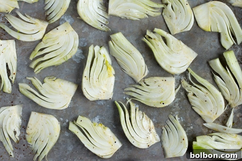 Close-up of cooked shrimp and roasted fennel on a baking sheet.