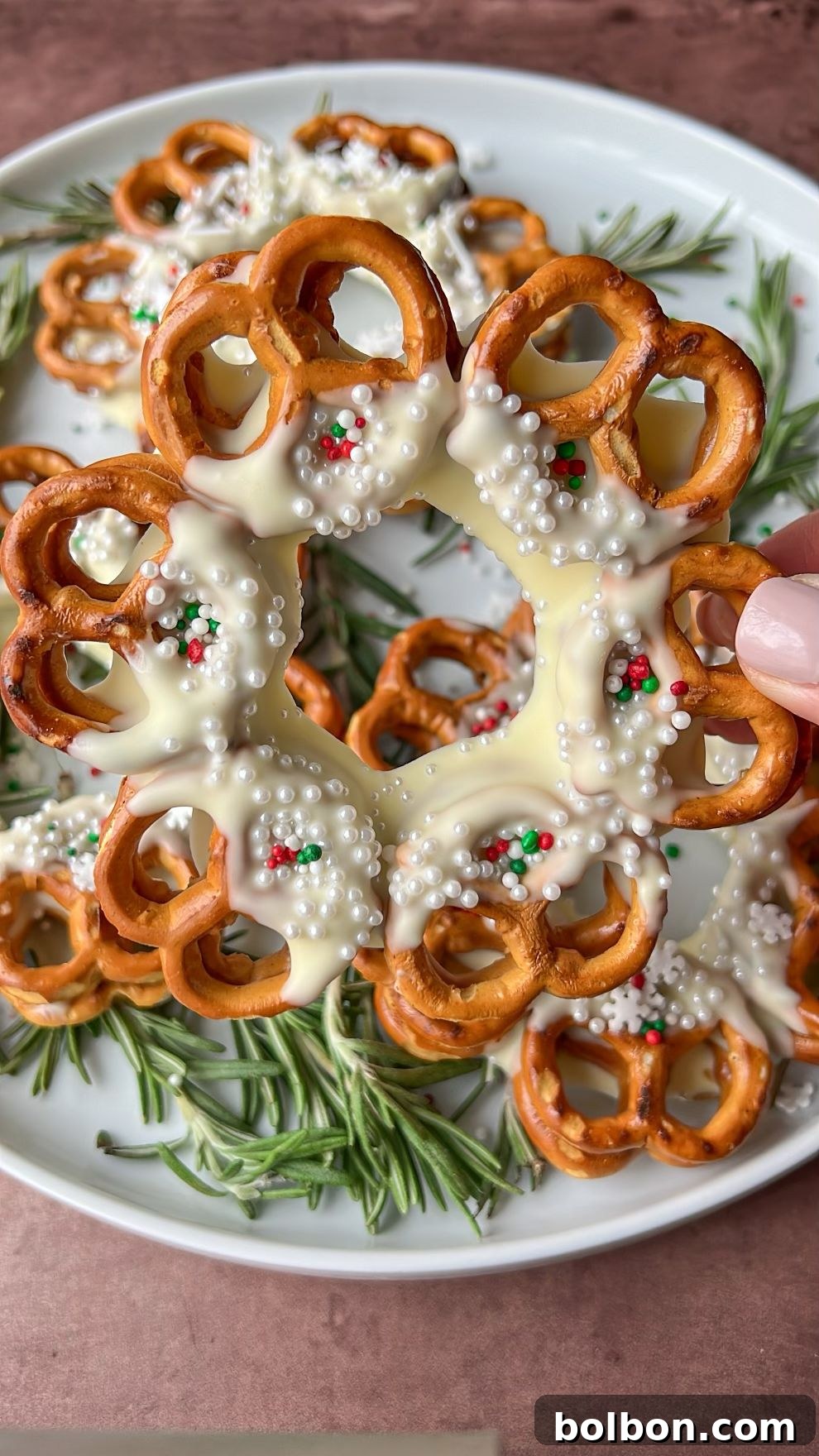 Festive Pretzel Christmas Wreath adorned with sprinkles on a baking sheet, ready for holiday celebrations.