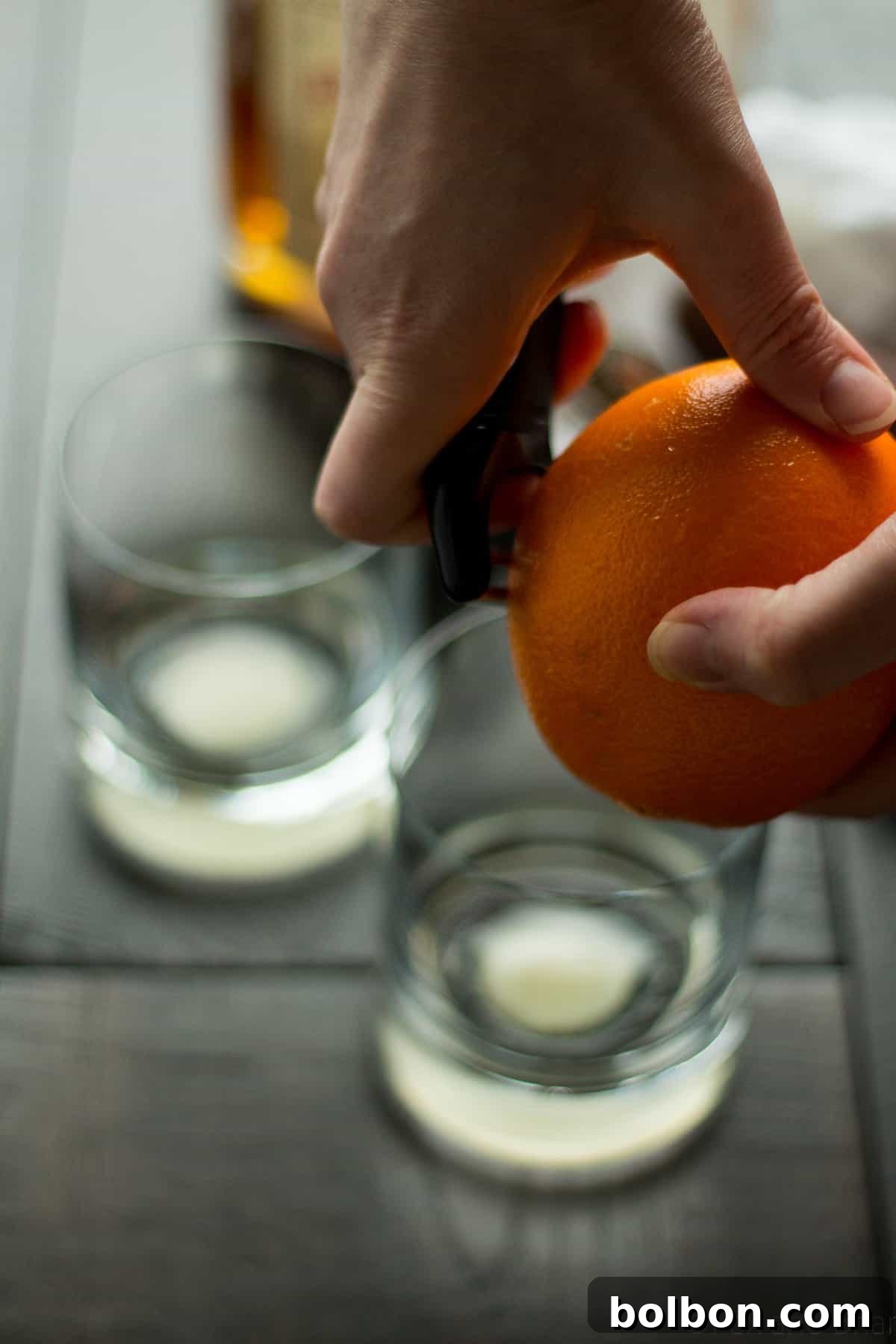 Close-up of an Apple Old Fashioned being prepared, highlighting the muddled sugar and bitters at the bottom of the glass before whiskey is added.