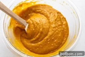 Smooth, well-mixed pumpkin bread batter in a glass bowl.
