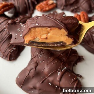 A plate of Healthy Chocolate Turtles—pecan caramel clusters dipped in rich chocolate, with one on a gold fork revealing gooey caramel and pecans, finished with a sprinkle of sea salt.