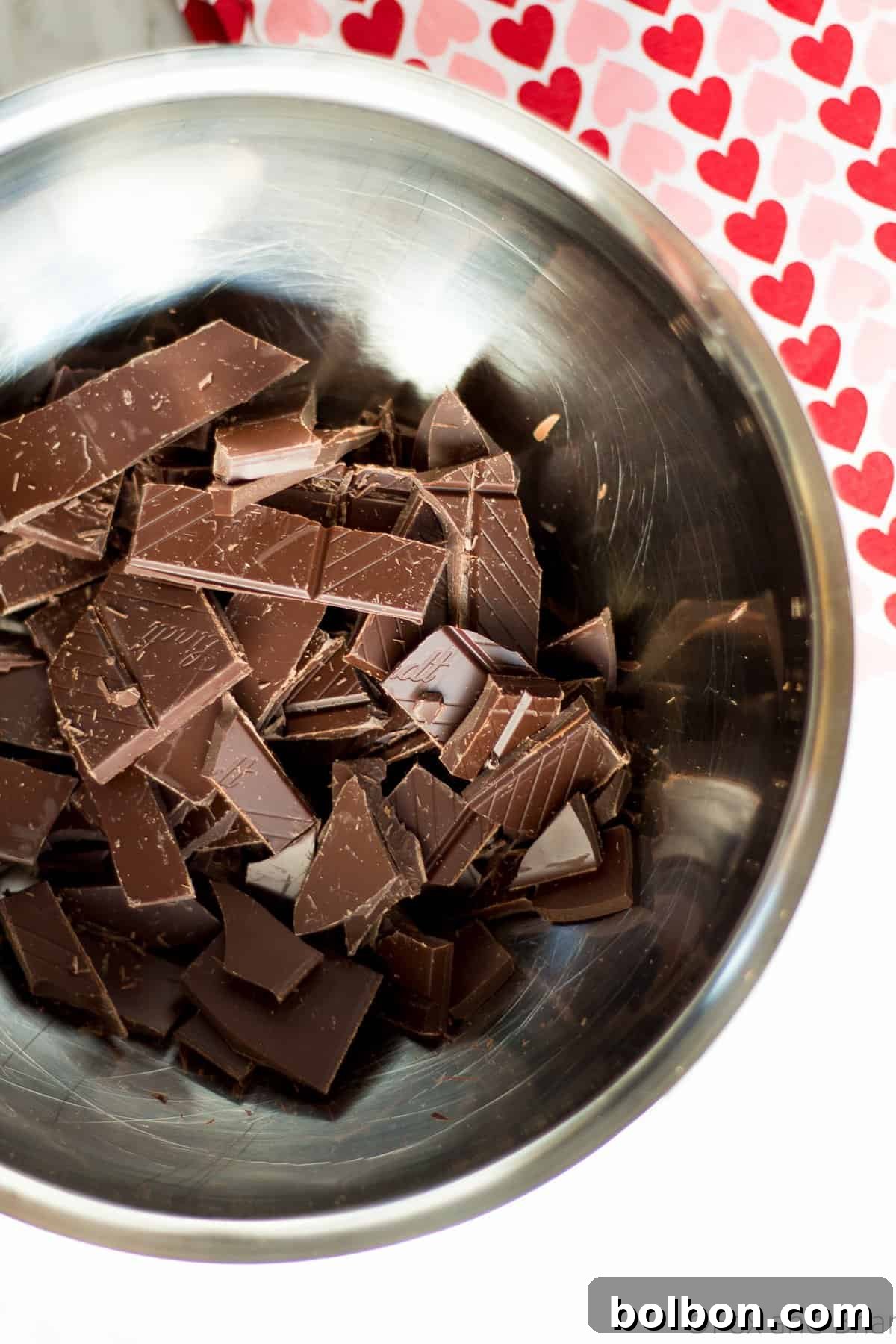 Close-up of smooth, dark chocolate fondue in a white ceramic bowl, ready for dipping, a rich and easy homemade dessert.