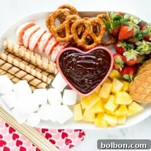 A bowl of rich, smooth chocolate fondue with a selection of fresh fruit and sweet dippers, an inviting and easy dessert.