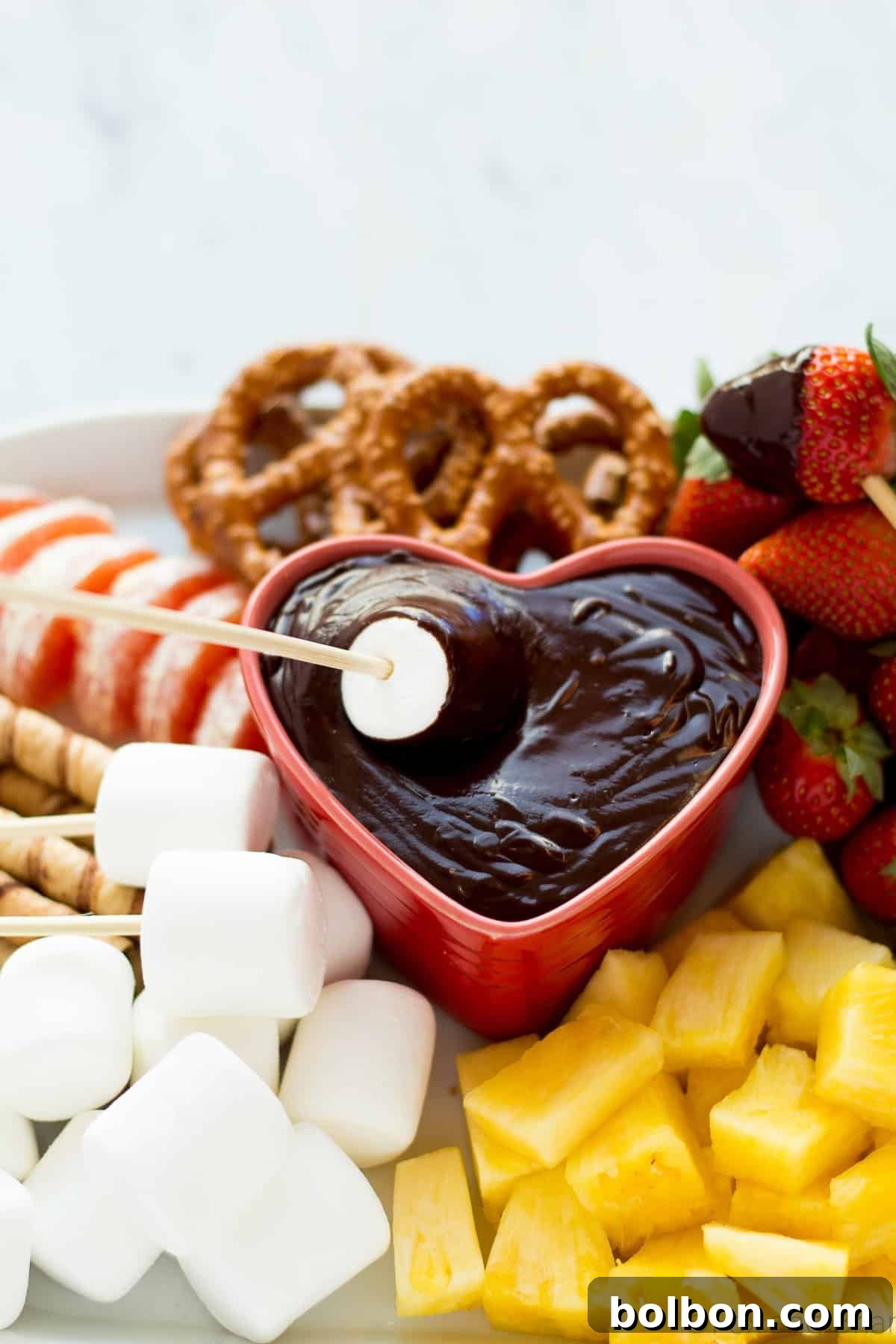 A stunning close-up of dark chocolate fondue with a selection of fresh fruit and marshmallows, presented beautifully for a special occasion dessert.