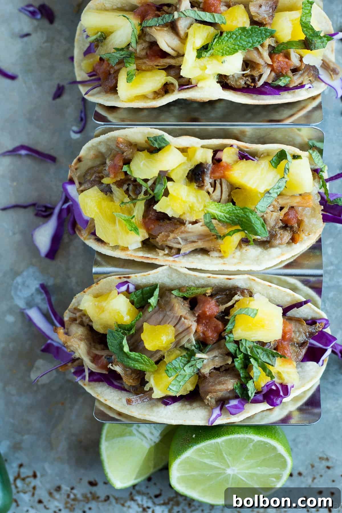 Assembled slow cooker pork tacos on a platter, showcasing all ingredients.