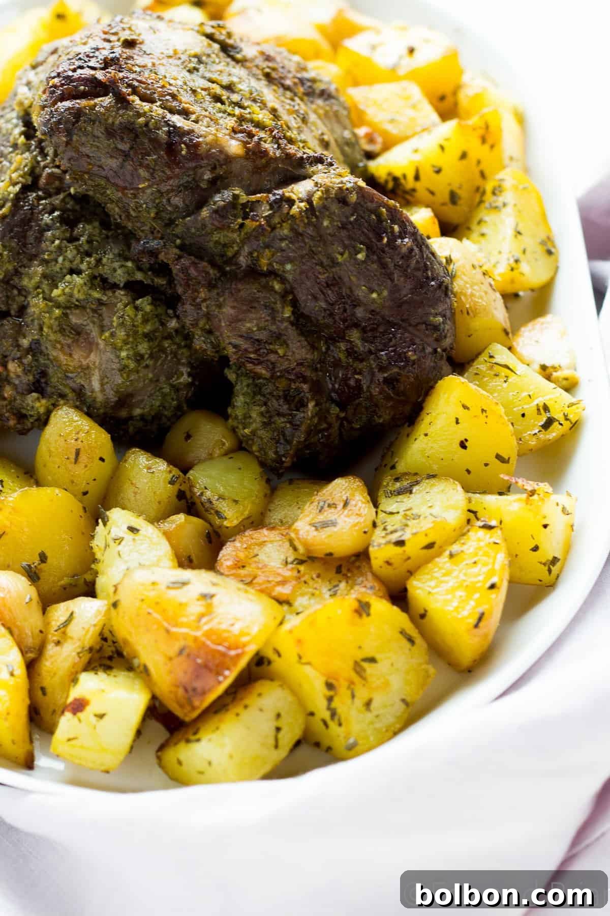 Perfectly sliced roasted boneless leg of lamb showcasing medium-rare doneness.