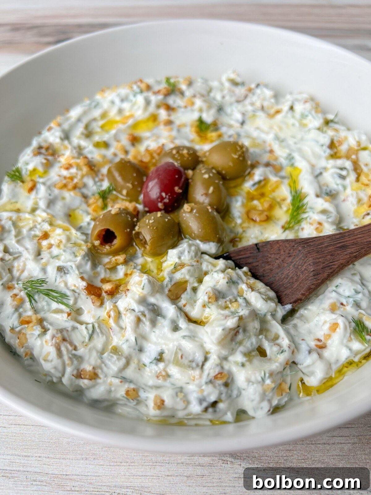 The Fairest White Salad 2 Snow White Salad Recipe - a creamy white dip in a bowl garnished with olives and dill
