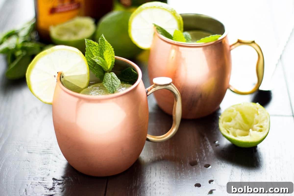 Emerald Kick 2 A refreshing Irish Mule cocktail in a copper mug, garnished with lime and mint.