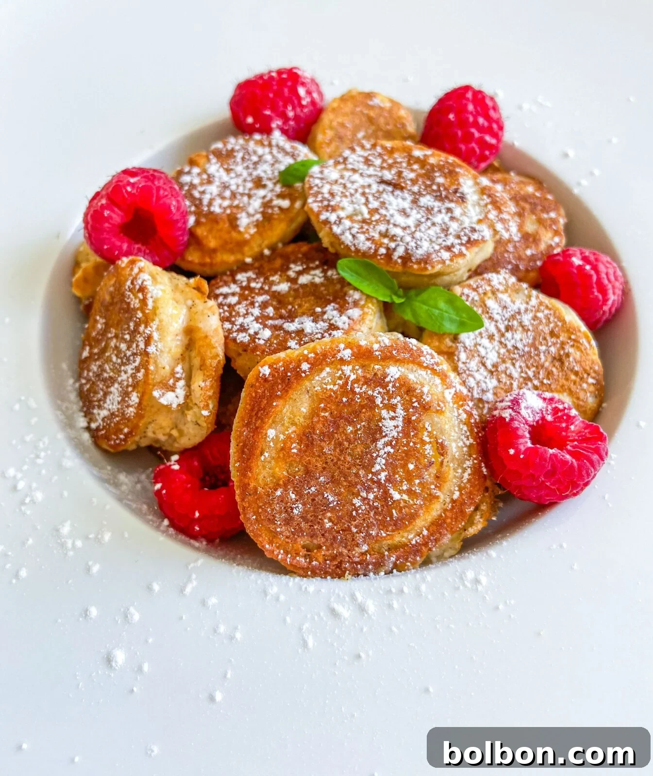Gluten Free Banana Pancakes, golden brown and perfectly cooked, stacked on a plate with fresh fruit.