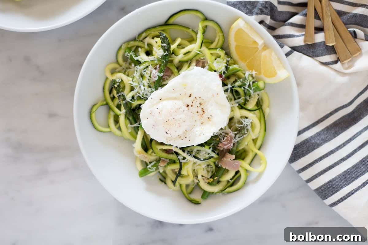 Zoodles (zucchini noodles) quick cooked with asparagus, prosciutto, parmesan cheese, lemon and white wine all topped with a poached egg make a quick and light spring meal.