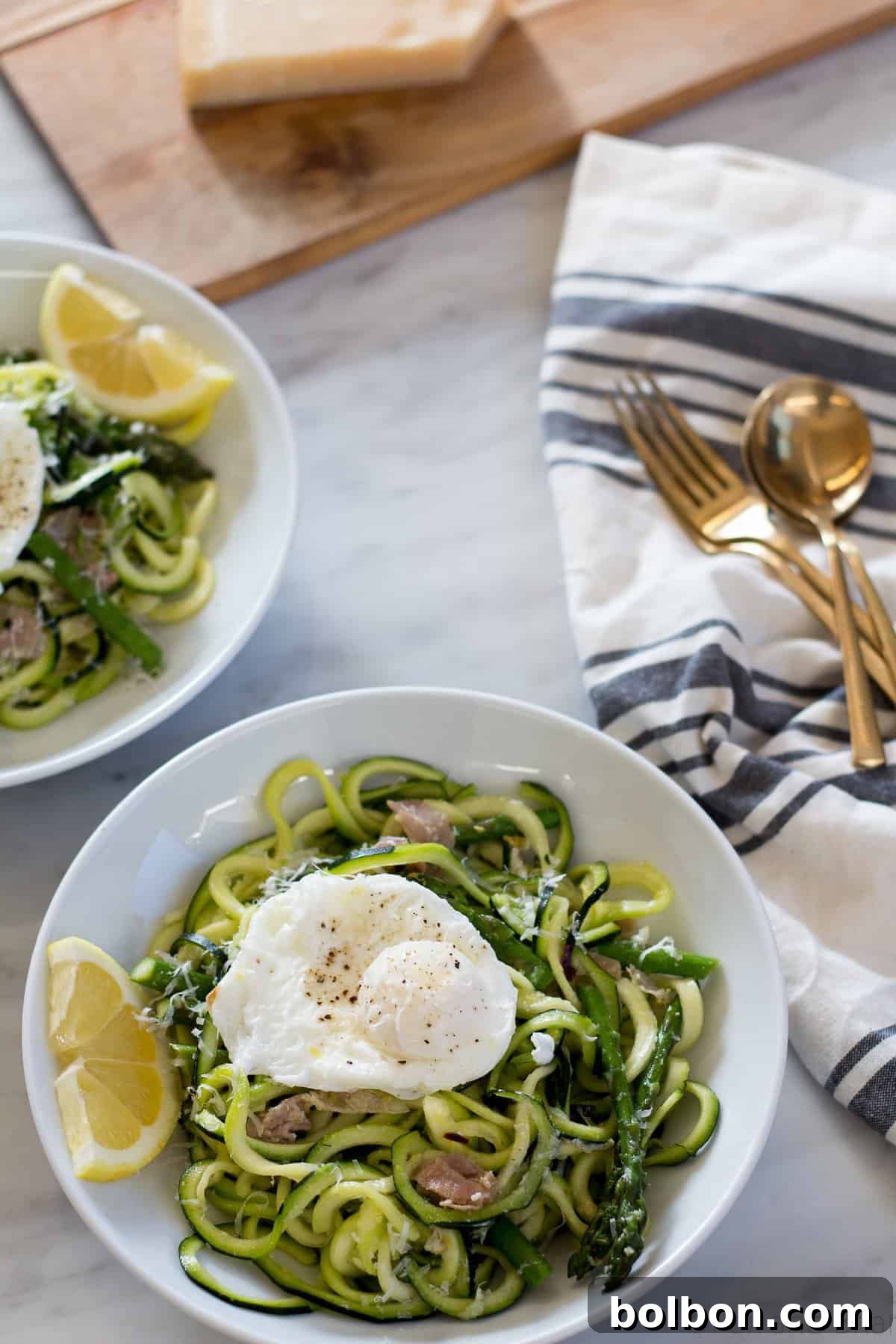 Zoodles (zucchini noodles) quick cooked with asparagus, prosciutto, parmesan cheese, lemon and white wine all topped with a poached egg make a quick and light spring meal.