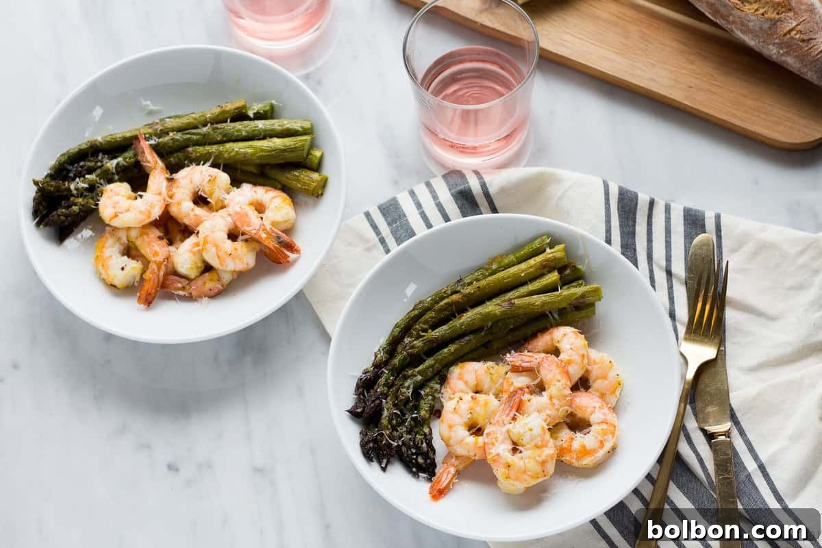 A perfectly roasted sheet pan meal with pink shrimp and tender green asparagus, ready to be served.