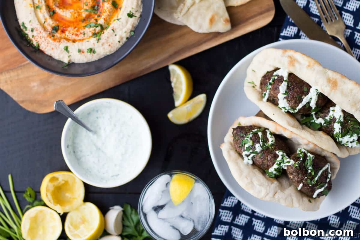 Grilled Lamb Kofta Kebabs on a platter, ready to be served with fresh herbs.