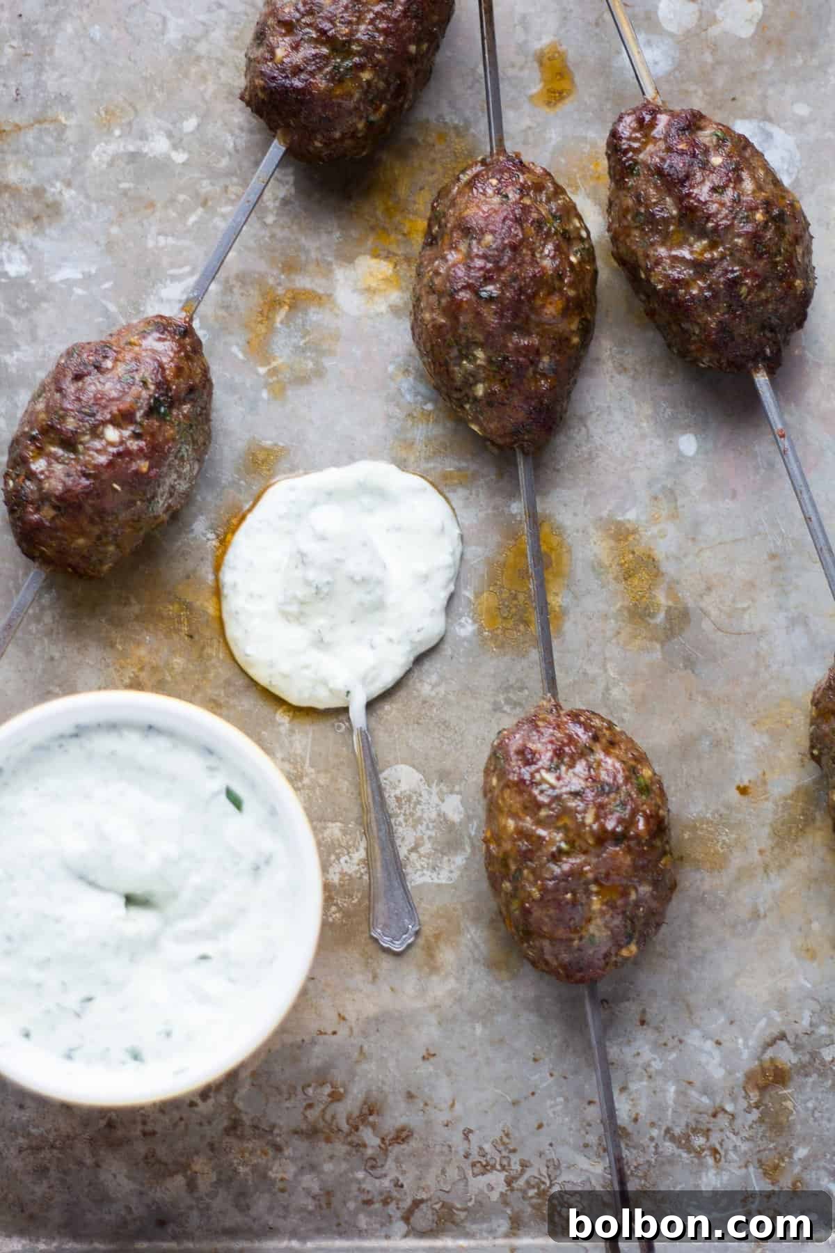 Close-up of perfectly grilled lamb kofta kebabs, showing the char marks and succulent texture.