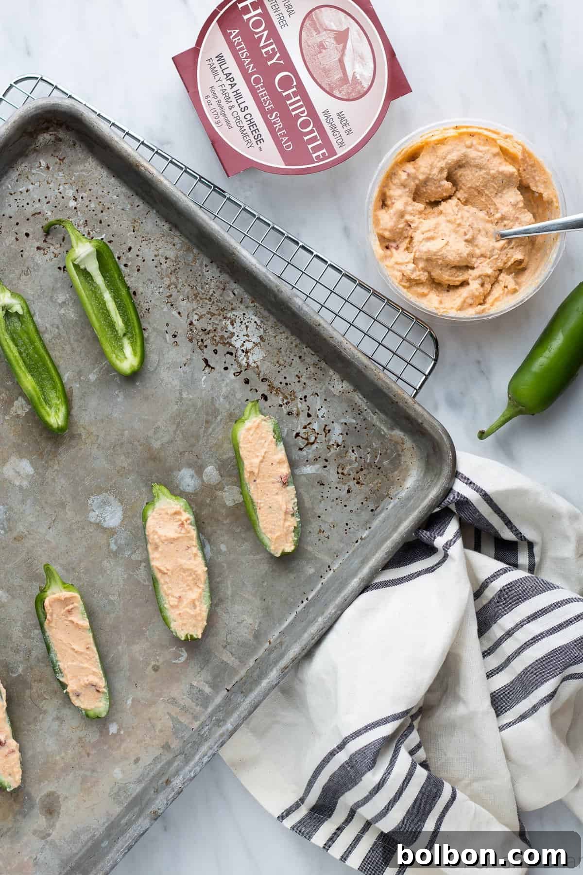 Close-up of baked honey chipotle jalapeno poppers, showcasing crispy bacon and melted cream cheese.
