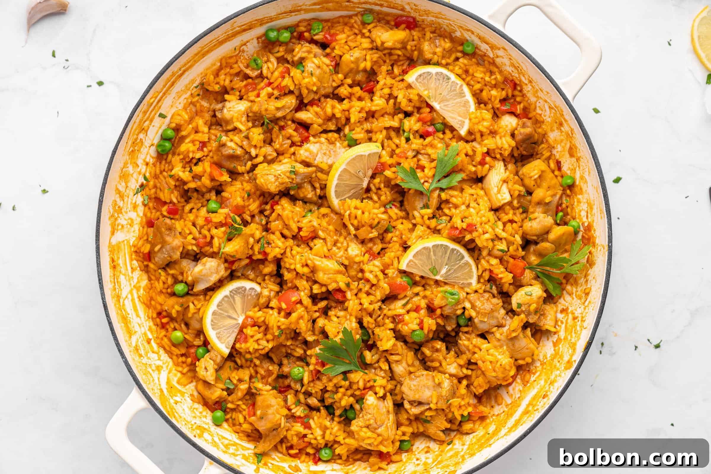 Chicken paella in a white skillet. 