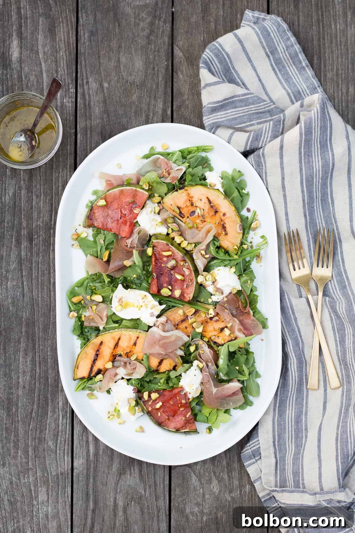 A beautifully presented Grilled Melon Salad with Prosciutto and Burrata, ideal for a light summer dinner