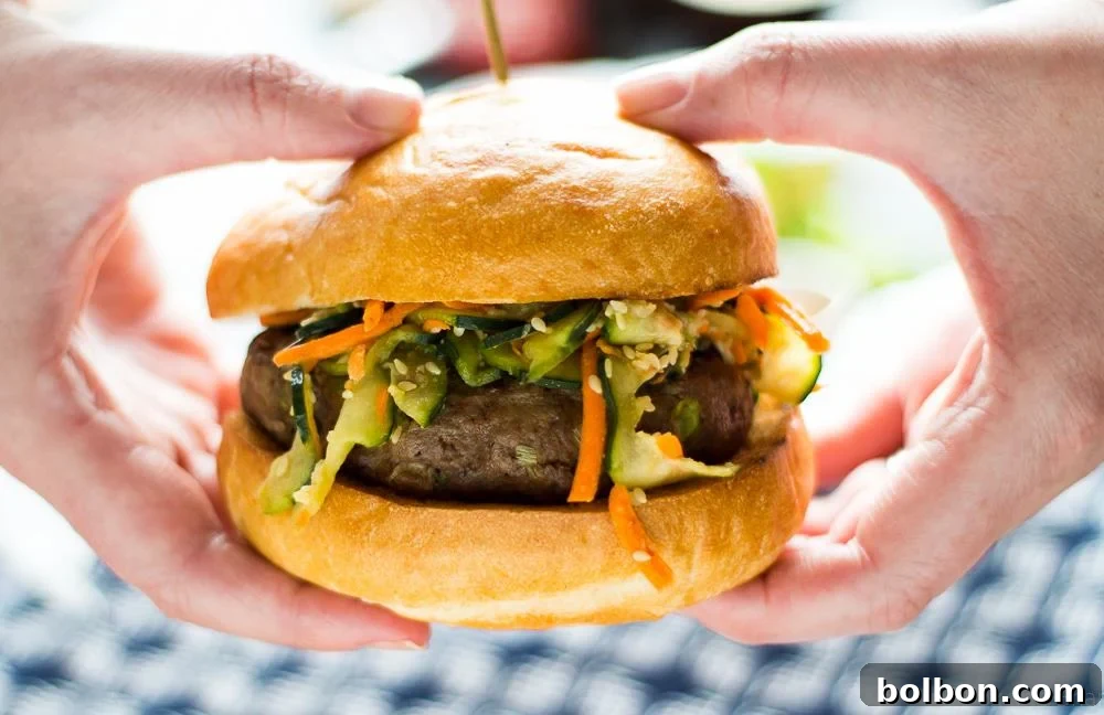Two Asian Bison Burgers on a cutting board with fresh garnishes