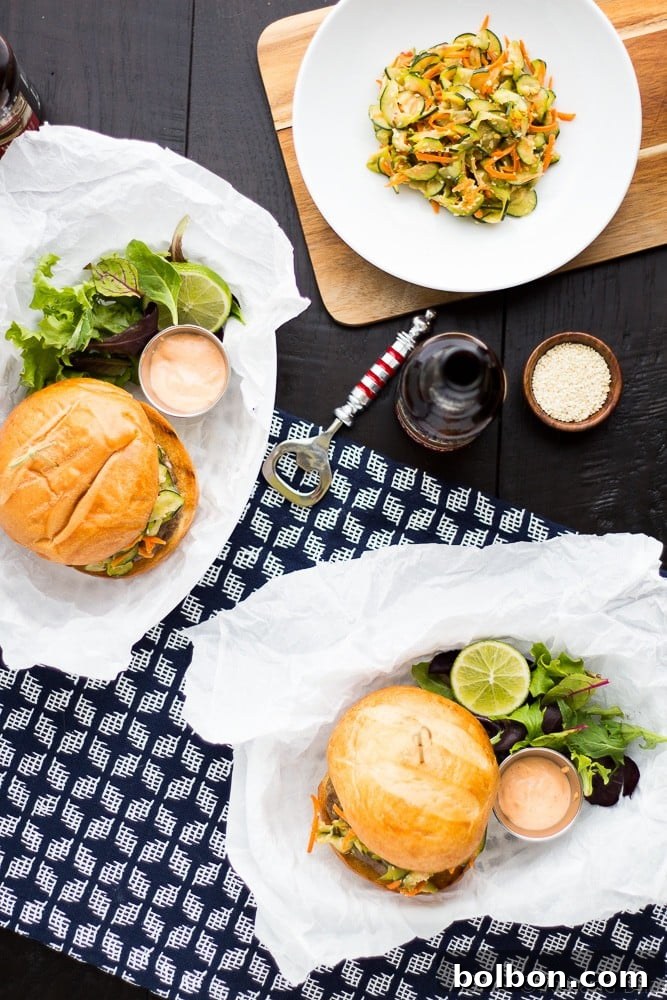 Plate of two Asian Bison Burgers with fresh slaw and sriracha aioli, ready to eat