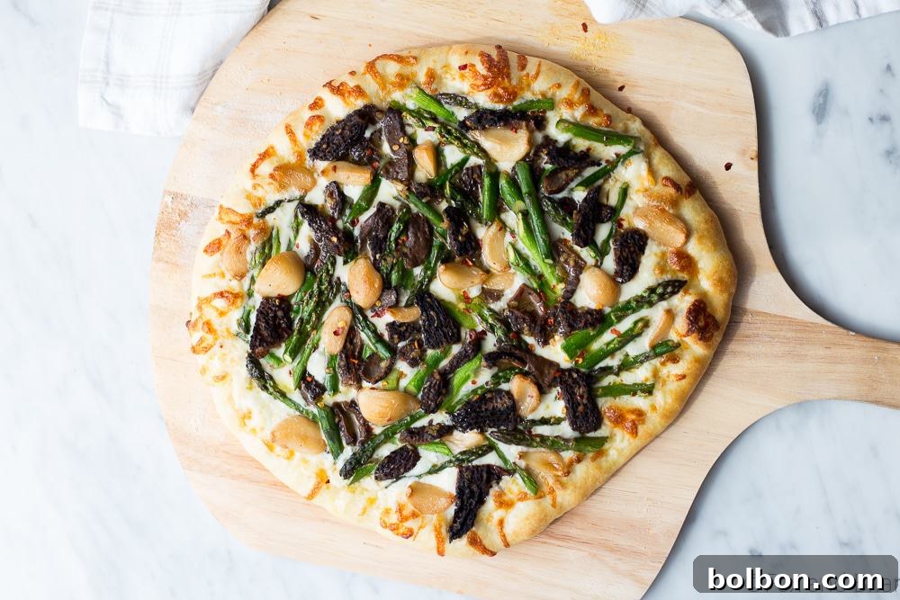 Delicious Asparagus and Morel Pizza with Garlic Confit, perfectly showcasing spring vegetables on a crispy crust.
