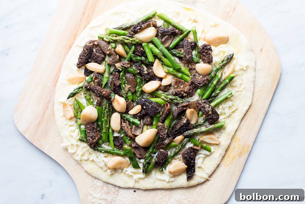 Close-up of freshly prepared Asparagus and Morel Pizza, highlighting the vibrant colors and rich textures of the toppings.