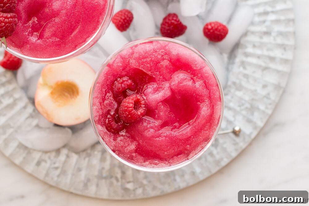 A pitcher and glasses filled with Raspberry Peach Frosé, ready for serving.