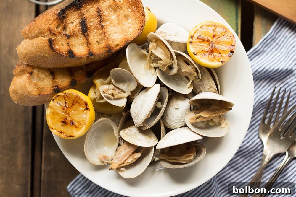 A close-up shot of beer steamed clams served in a bowl with lemon wedges and fresh herbs, inviting to eat.