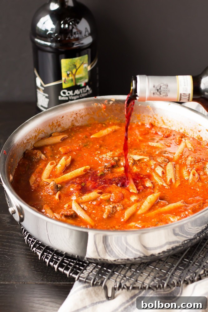 Sausage and Wine Pasta Bake: A Comfort Food Classic Made Simple Hearty One Pot Pasta Bake with Sausage, Wine, and melted cheese in a skillet