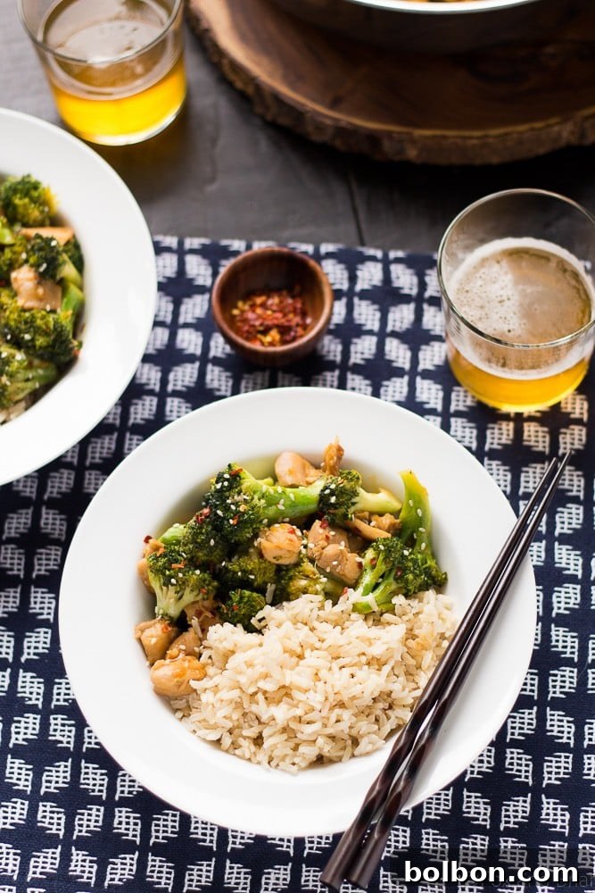 A serving of Healthier One Pan Orange Chicken and Broccoli with a garnish of sesame seeds