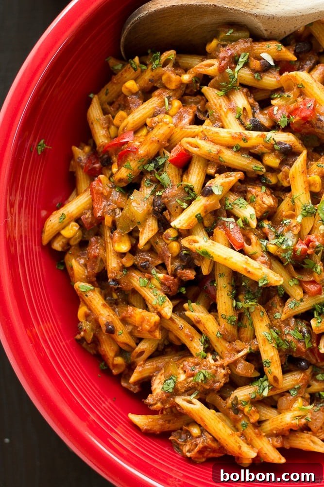 The Ultimate Chicken Taco Pasta And a Giveaway 6 A large serving of Chicken Taco Pasta in a skillet, showcasing the melty cheese and vibrant ingredients. A hearty and quick dinner solution.