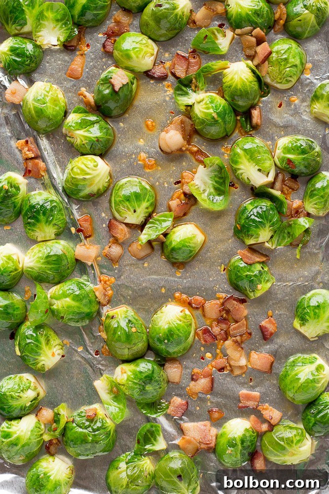 A close-up of beautifully roasted Brussels sprouts with crispy bacon bits and a maple glaze, ready to be served.