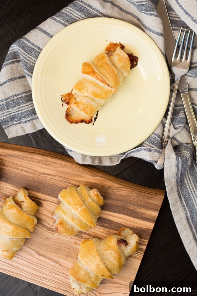 A close-up showing the interior of a sliced ham and cheese croissant, revealing the layers of ham and melted Gruyère cheese.