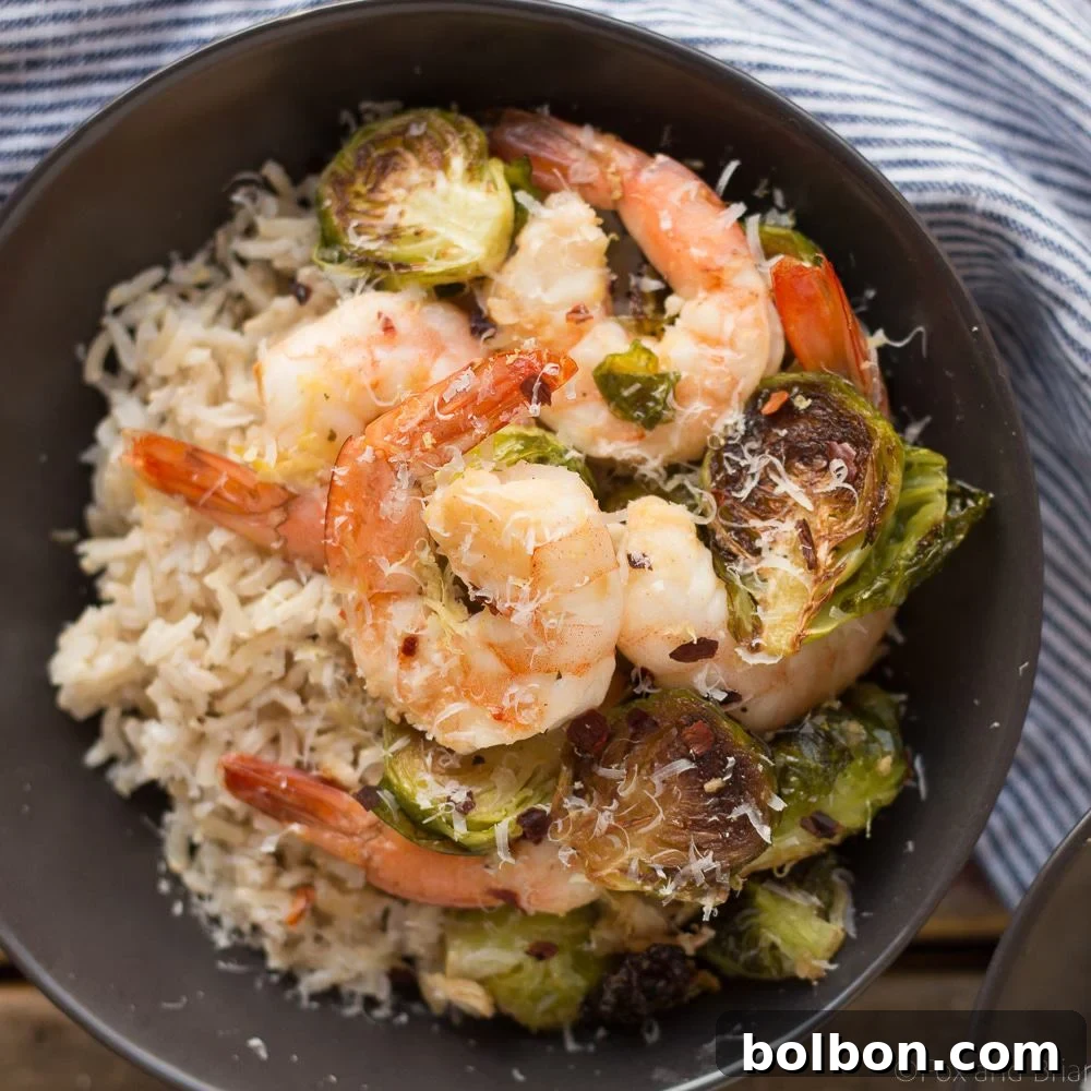 A perfectly roasted sheet pan dinner featuring succulent lemon garlic shrimp and caramelized Brussels sprouts, garnished with fresh parsley.