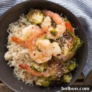 A vibrant close-up of the finished Roasted Shrimp and Brussels Sprouts sheet pan dinner.