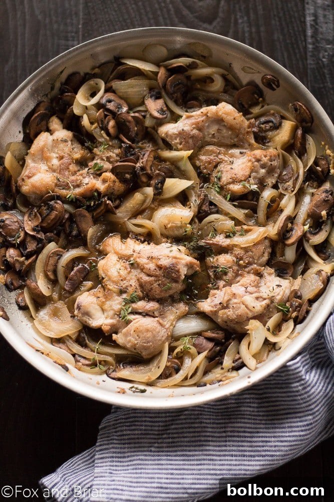 Skillet Chicken with Wine-Kissed Mushrooms 5 Close-up of golden-brown chicken thighs and sautéed mushrooms in a skillet, ready for the white wine sauce.