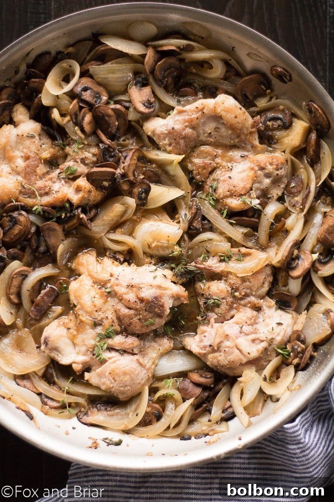 Skillet Chicken with Wine-Kissed Mushrooms 6 Cooked Skillet Chicken and White Wine Mushrooms garnished with fresh thyme, served in a cast iron pan.