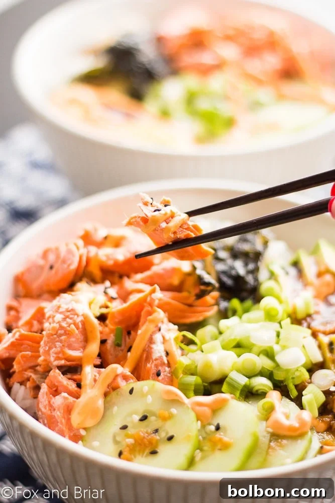 A beautifully presented Salmon Sushi Bowl, garnished with sesame seeds and fresh green onions, ready for a satisfying meal.