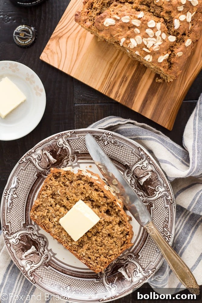 Traditional Irish Guinness Brown Bread 4 A slice of Irish Guinness Brown Bread ready to be enjoyed, highlighting its moist interior and oat topping