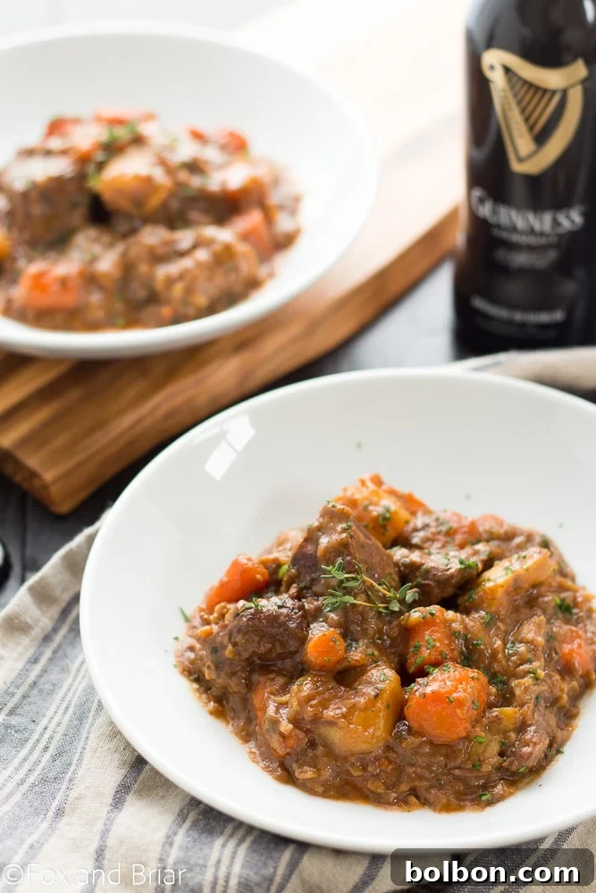Guinness-Laced Irish Beef Stew 2 Rich and hearty Irish Guinness Beef Stew with tender beef and vegetables, served in a bowl on a rustic table.