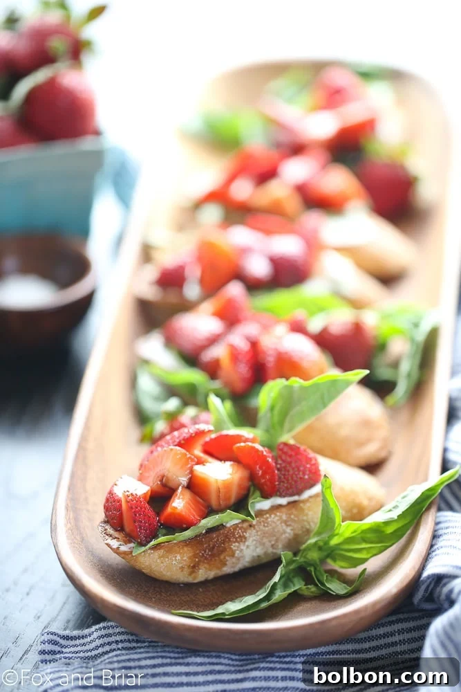 Artfully arranged Strawberry Chambord Whipped Cheese Toasts, with fresh strawberries and basil