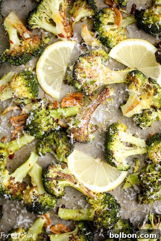 Crispy Lemon Parmesan Roasted Broccoli, garnished with fresh lemon zest and Parmesan cheese, on a white plate