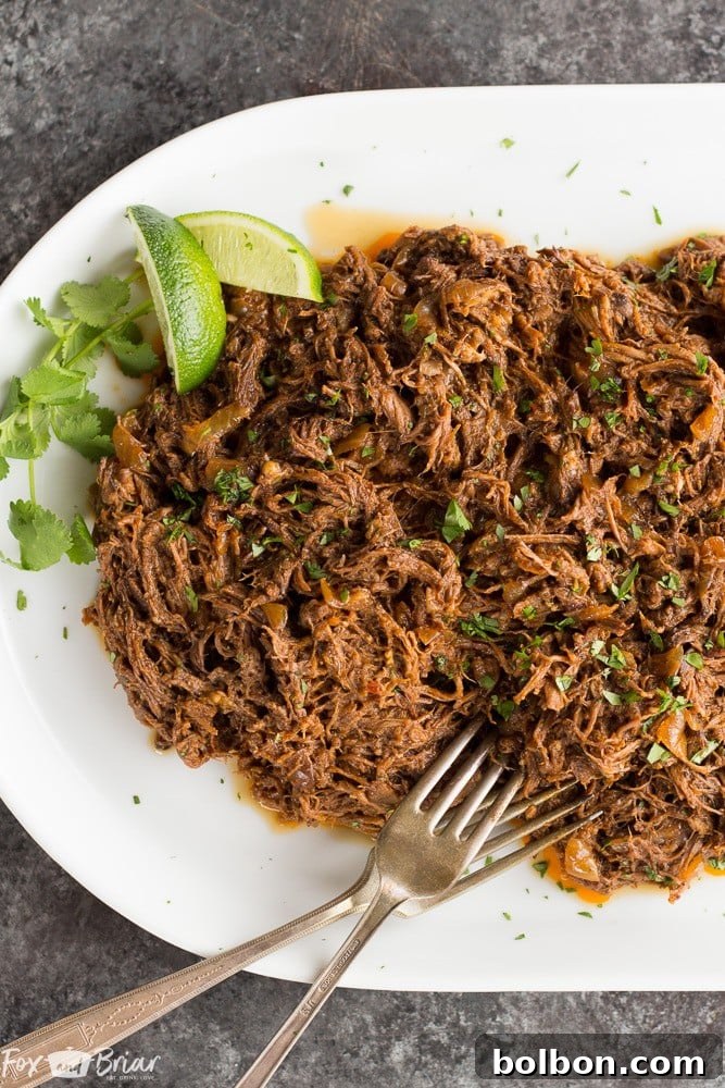 A close-up shot of juicy Slow Cooker Mexican Shredded Beef, perfect for tacos and burritos, garnished with fresh cilantro.