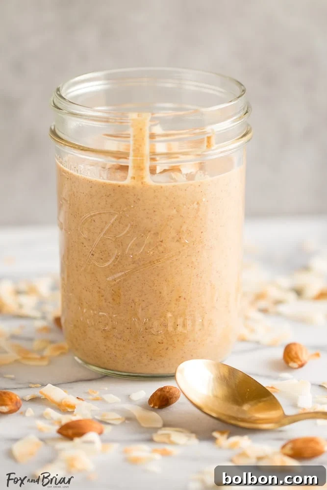 Creamy homemade toasted coconut almond butter in a jar, perfect for paleo and whole30 diets.