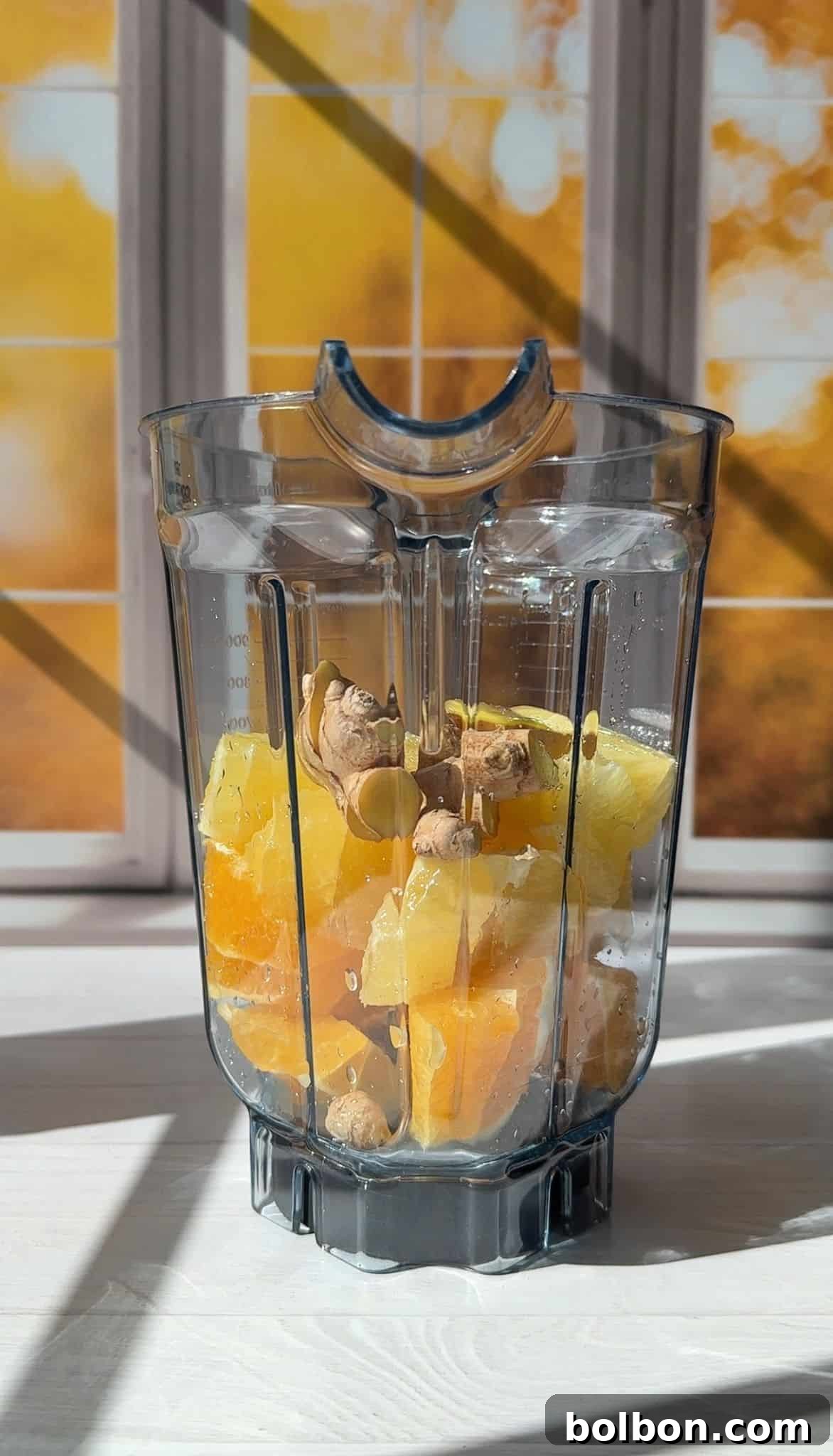 adding oranges, lemons, ginger, and pepper to a blender which is the starting process of making the best ginger shots ever! 