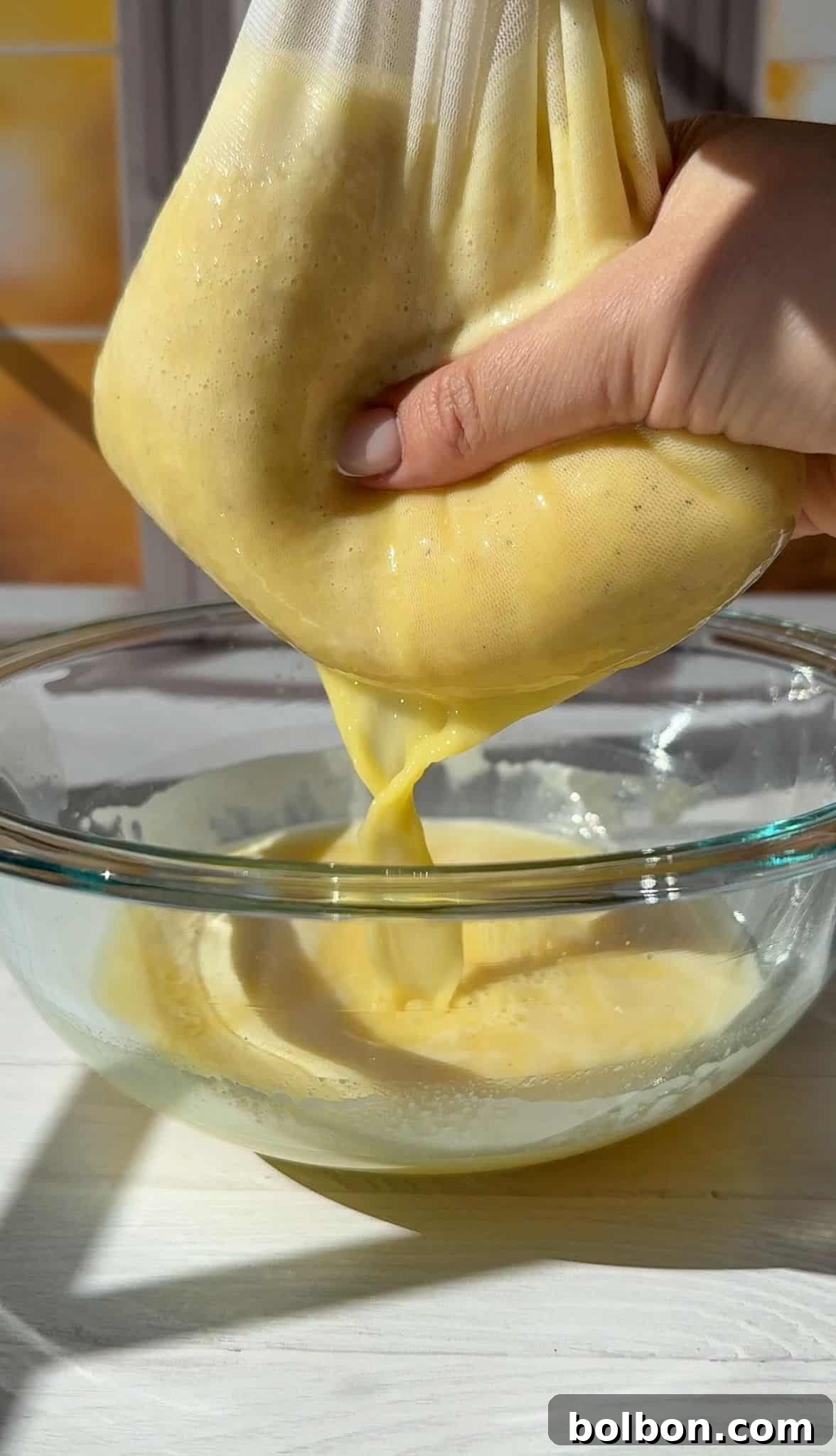 Squeezing the nut milk bag with the juice over a bowl to catch the pulp