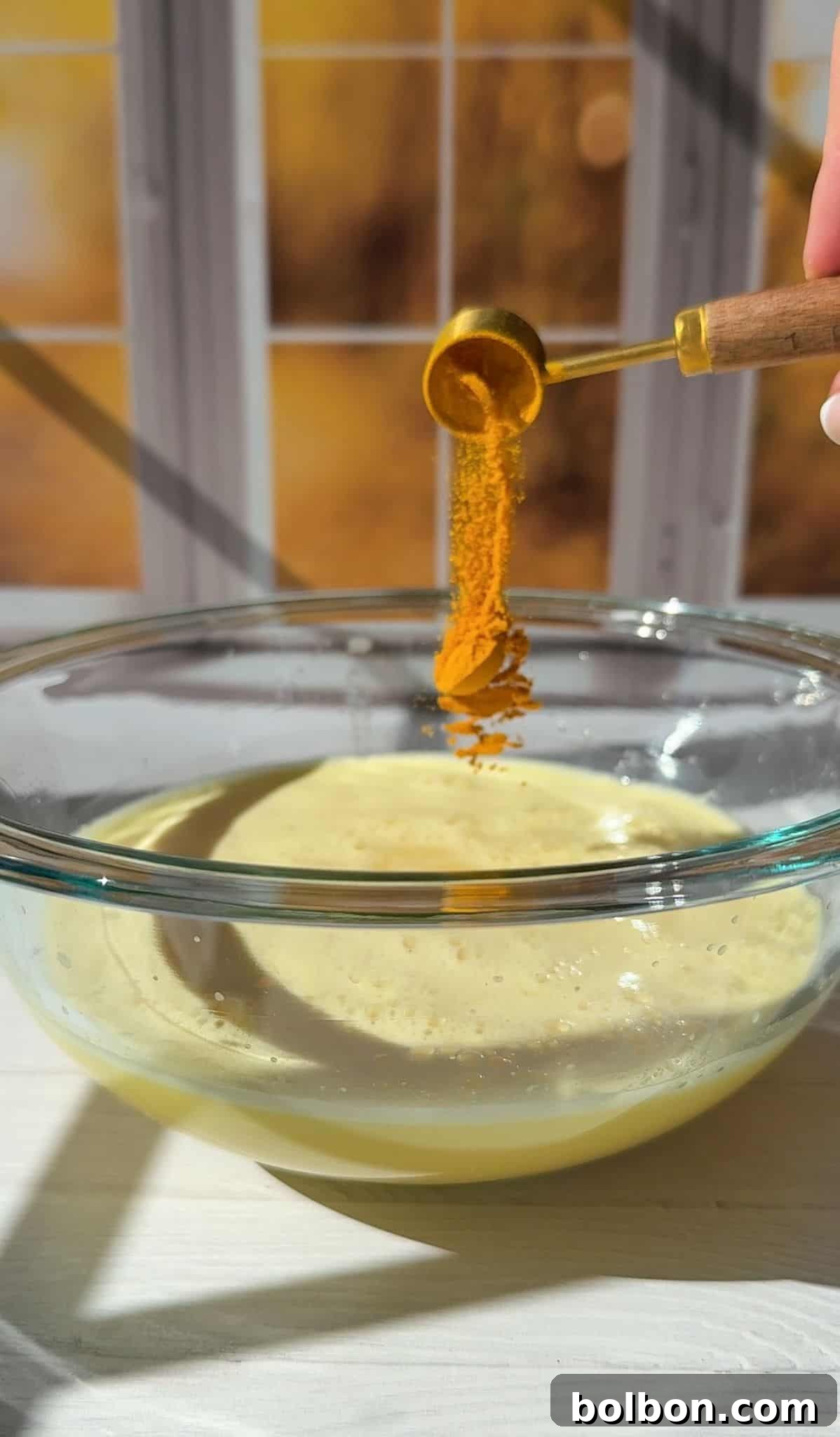 adding organic ground turmeric to the strained juice and mixing it