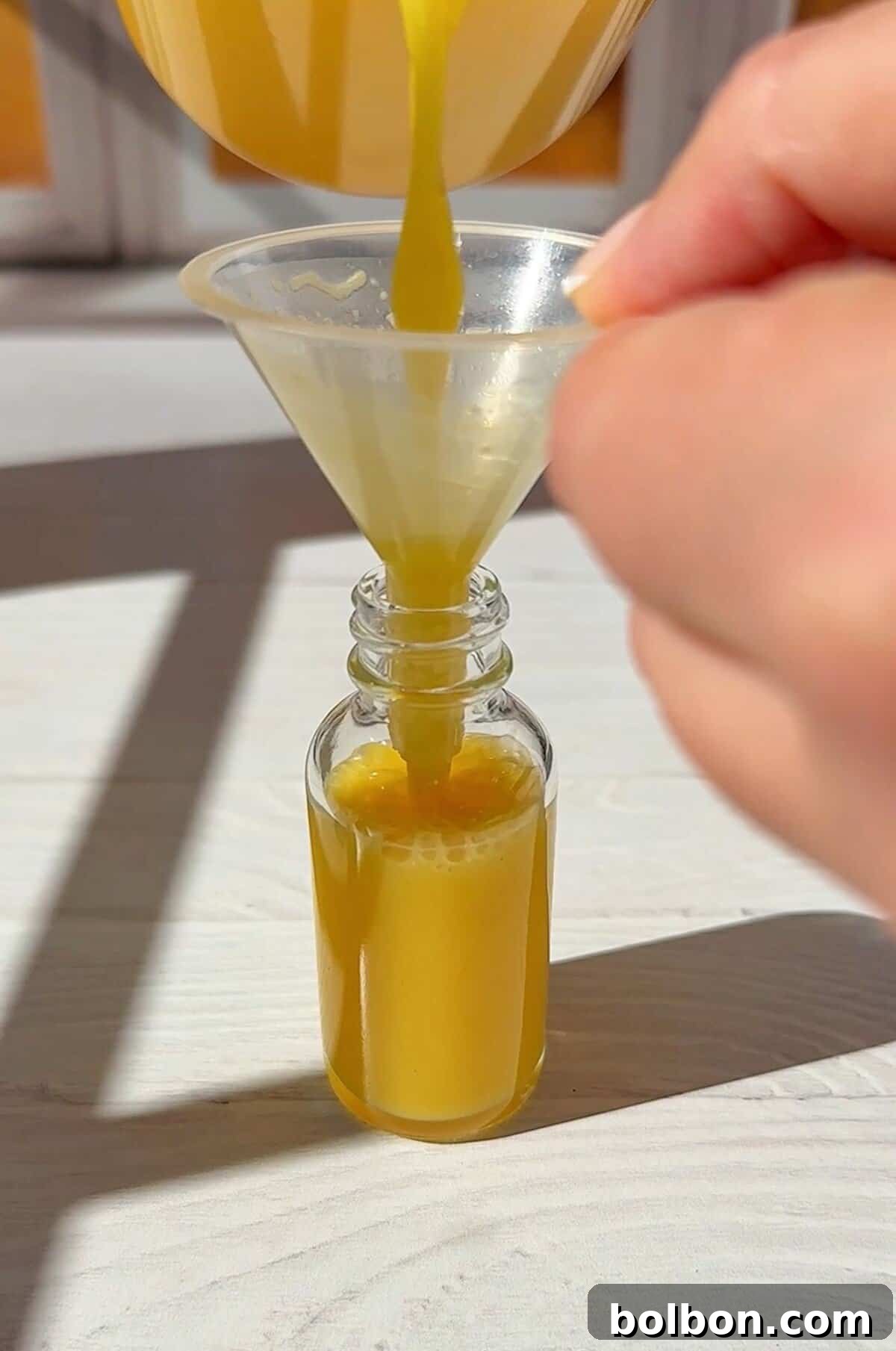 pouring the juice into our ginger shot bottles with a small funnel. You have now made your ginger shots. 