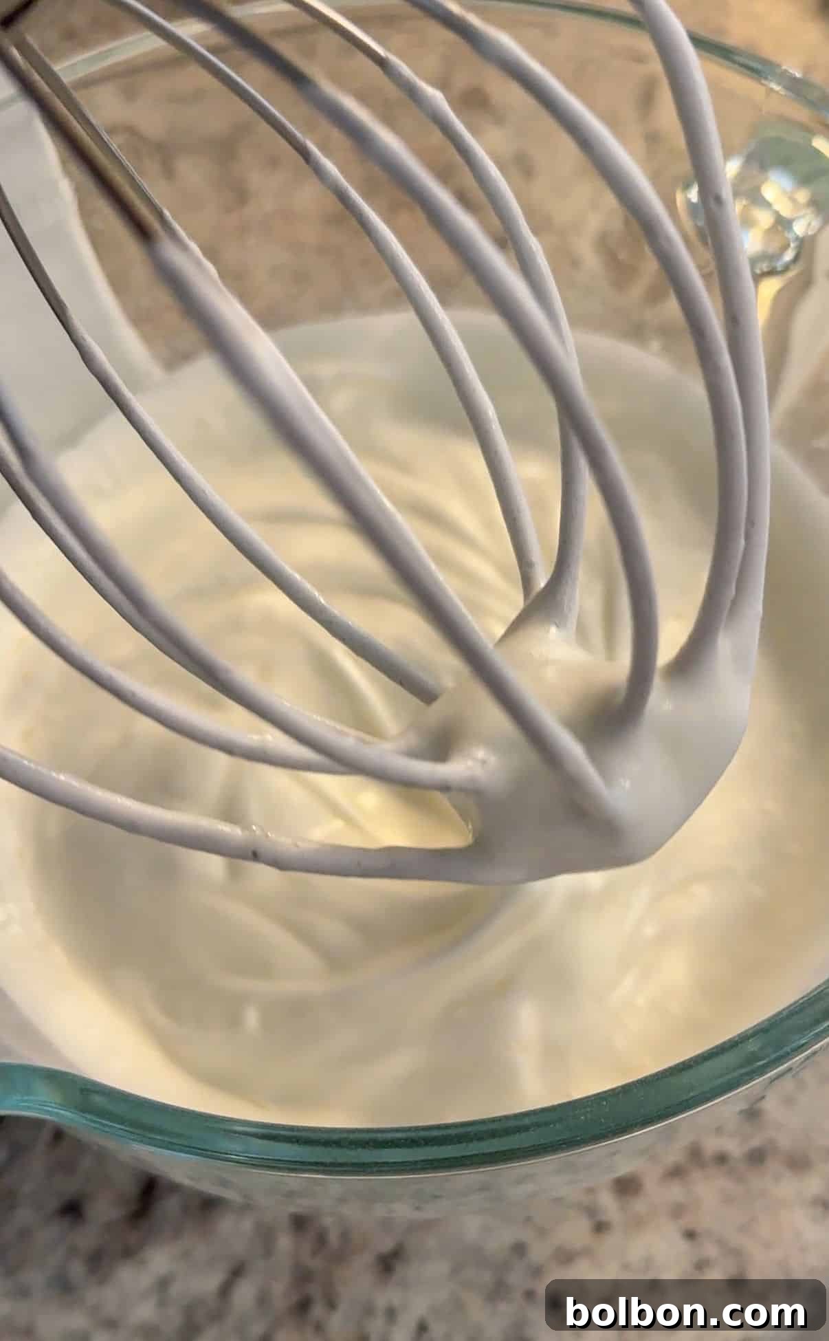 Egg white powder and water being whisked in a stand mixer.