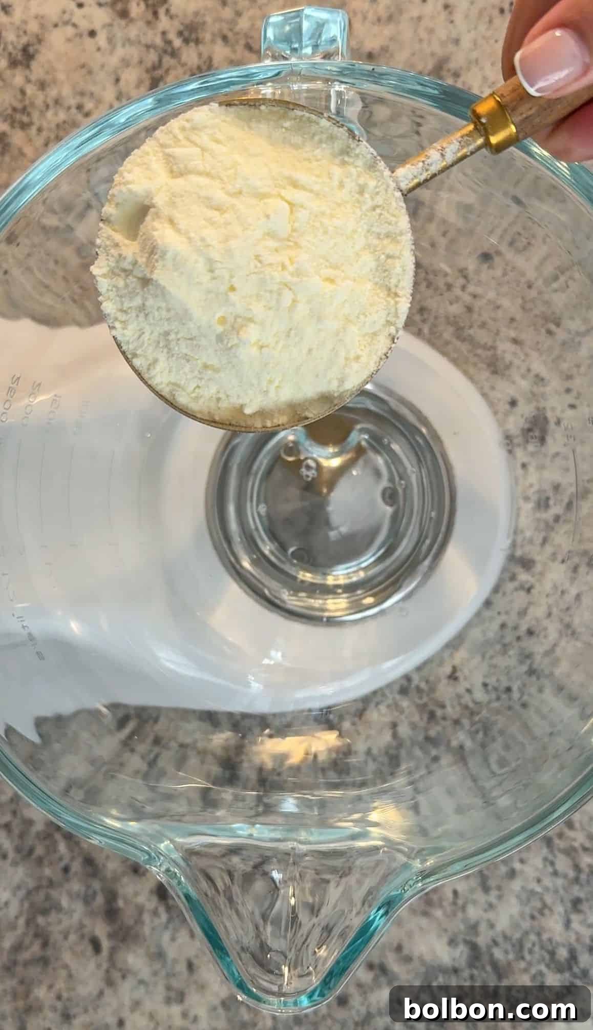 Stiff peaks formed by whipped egg whites in a stand mixer, ready for the next step.