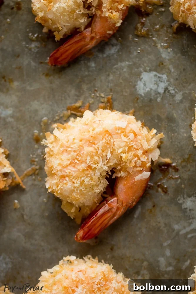 Restaurant-Quality Baked Coconut Shrimp at Home 4 A close-up of a batch of golden and healthy baked coconut shrimp.